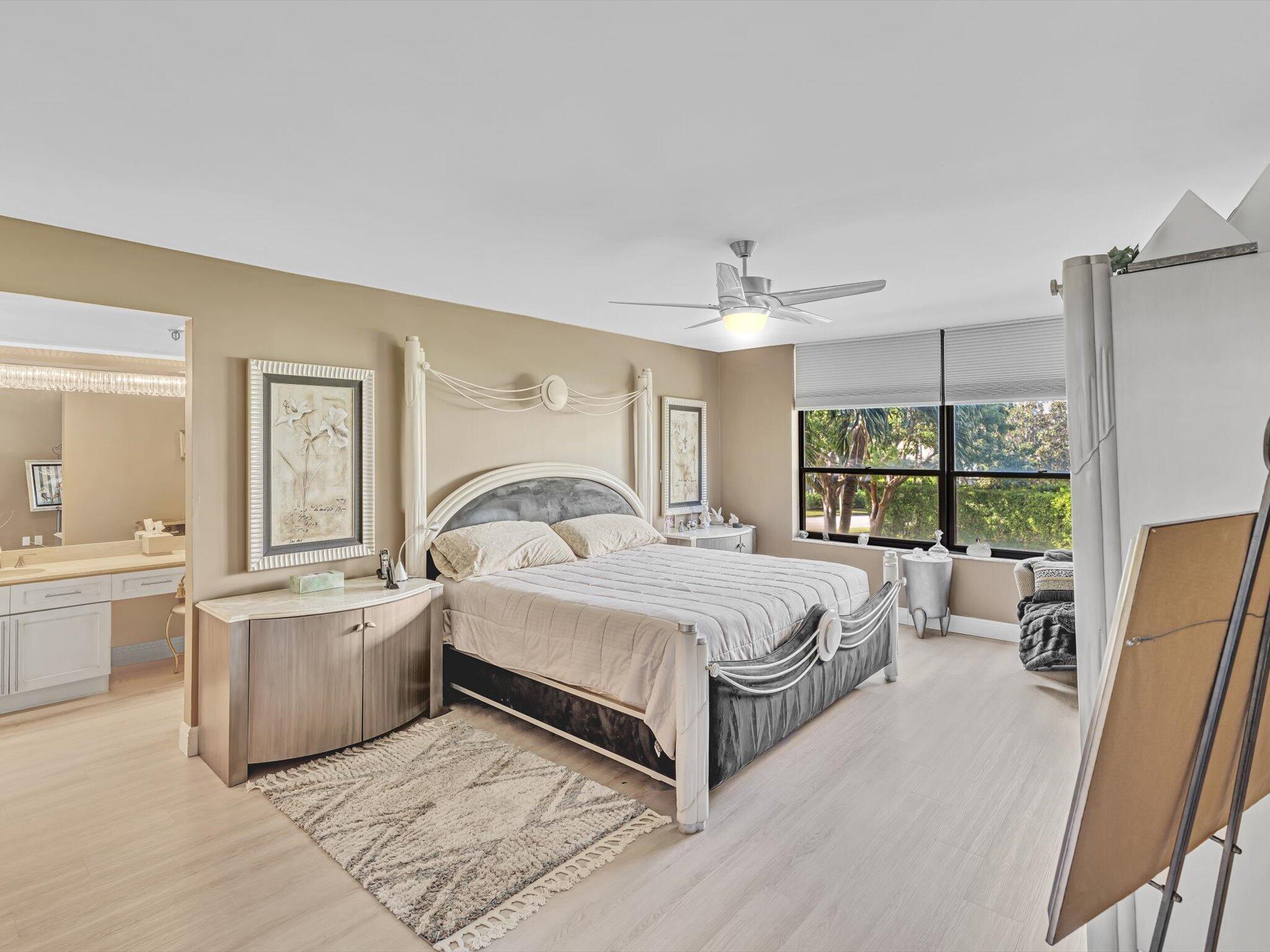 a spacious bedroom with a large bed and a chandelier