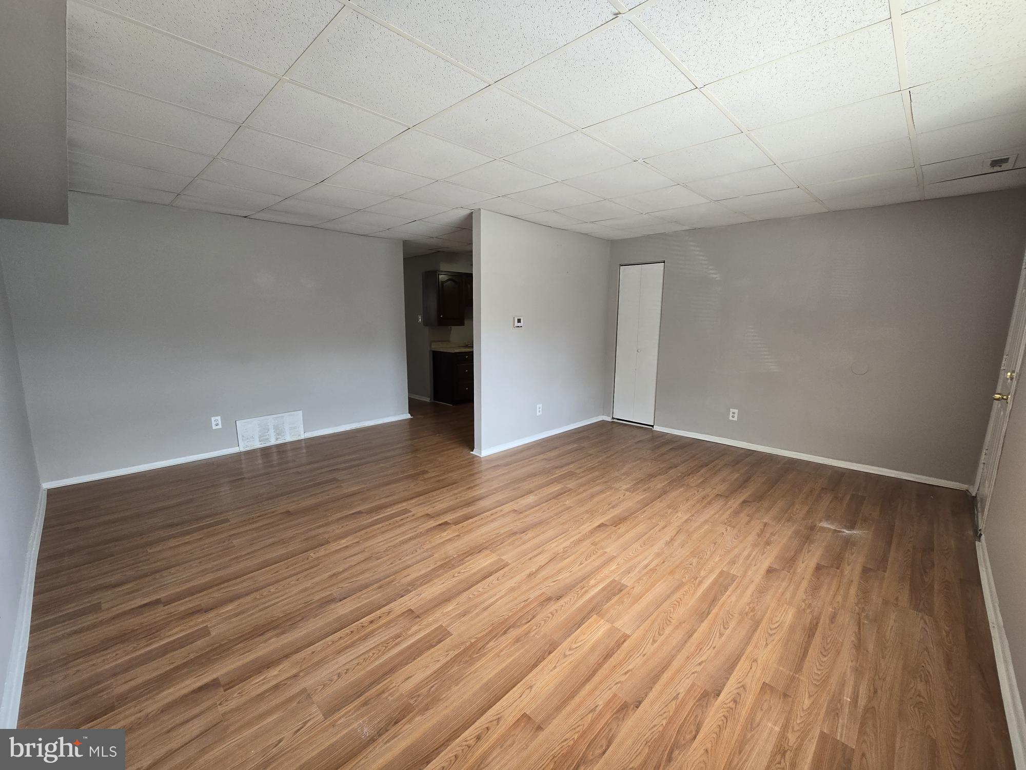 a view of empty room with wooden floor