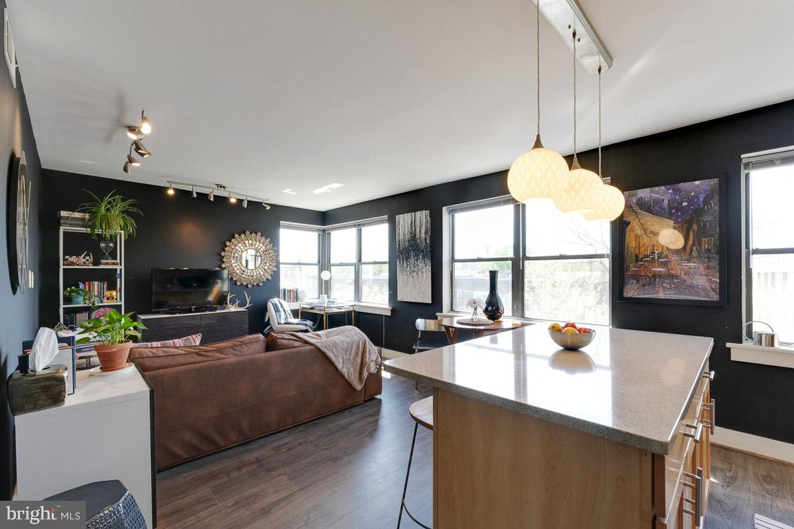 a living room with furniture a flat screen tv and a large window