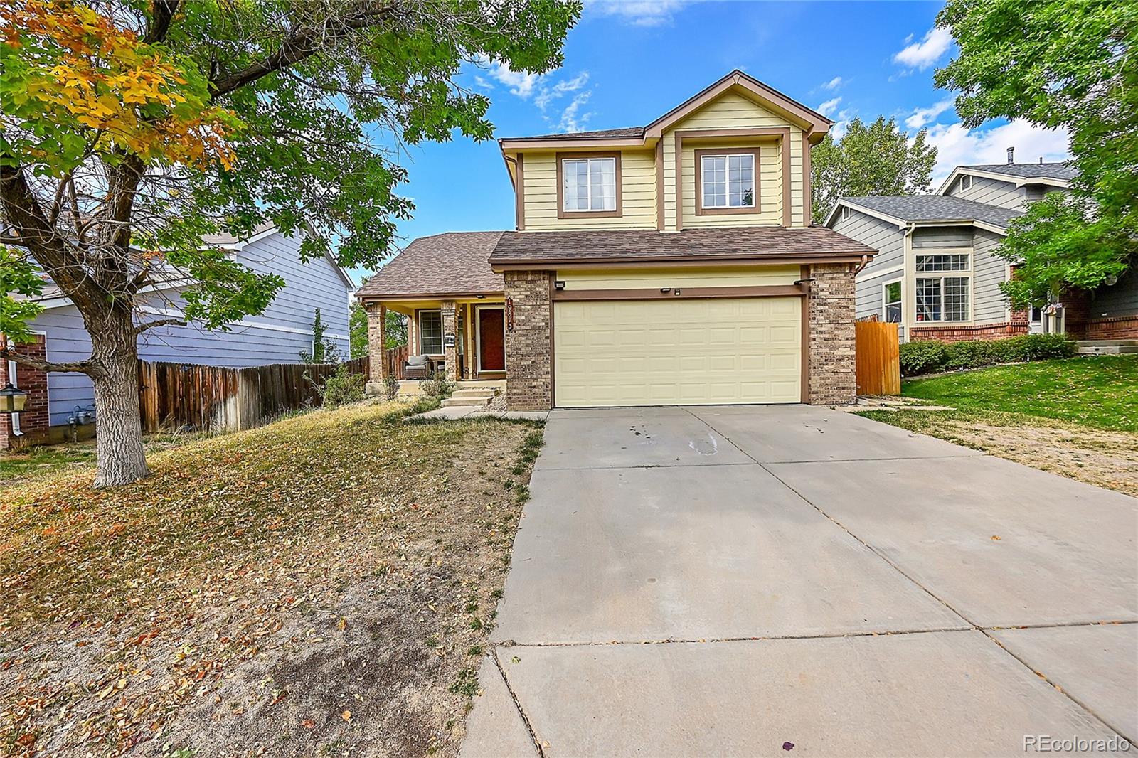 a front view of a house with yard and parking