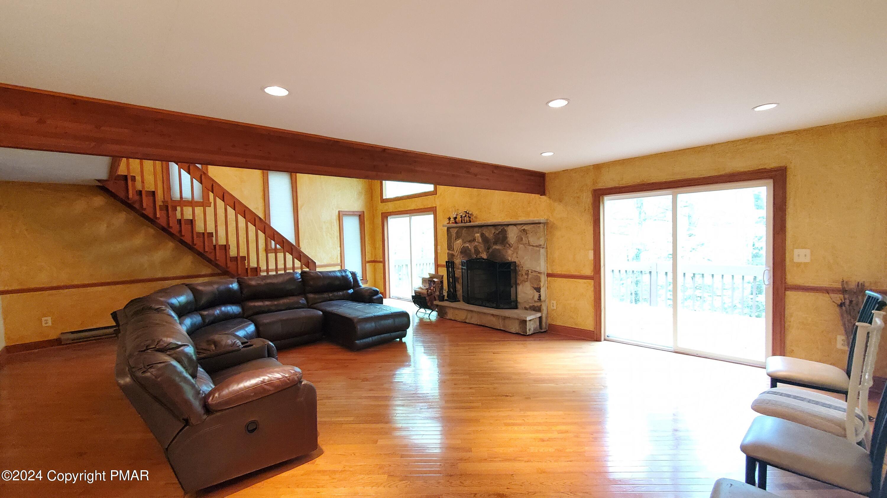 a living room with furniture floor to ceiling window and a flat screen tv