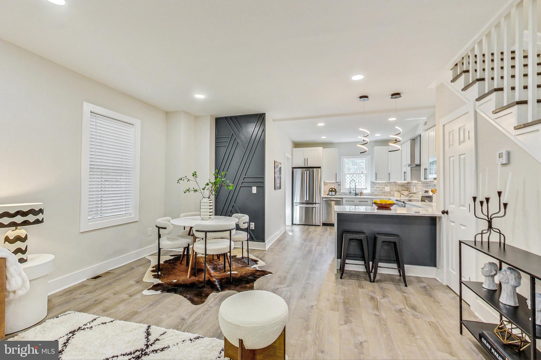 a living room with furniture and a dining table with kitchen view