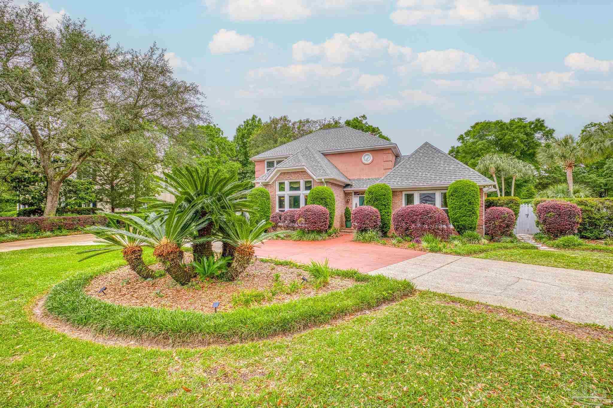 a view of a house with a yard and potted plants