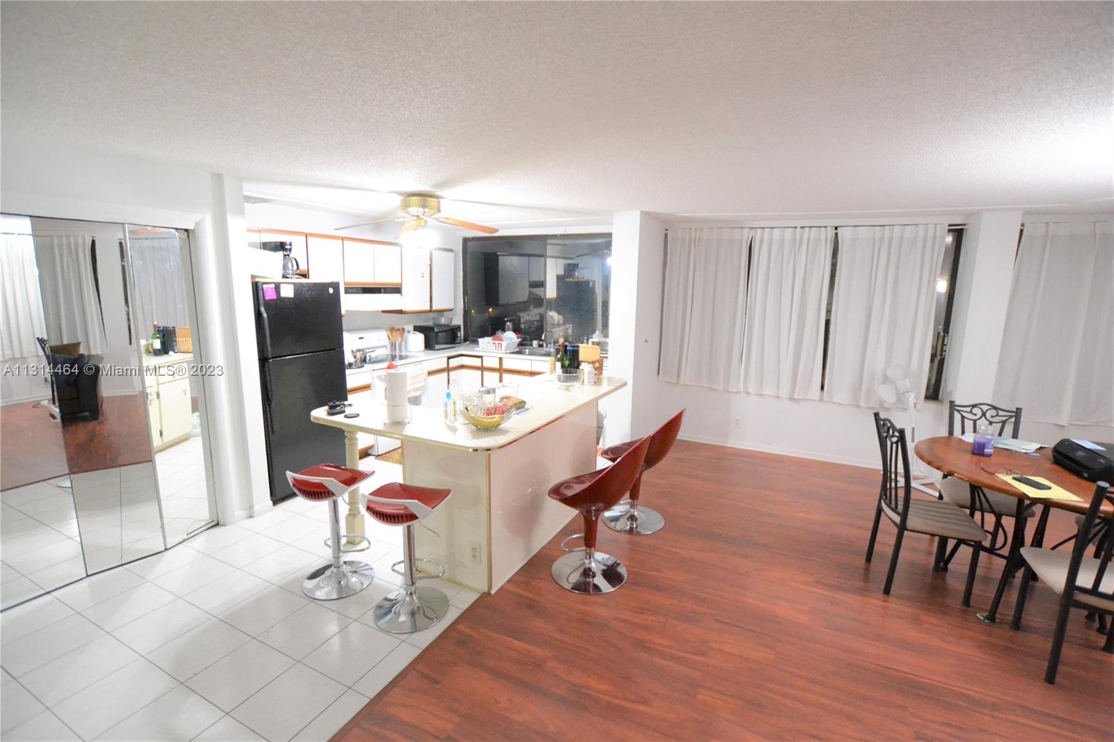 a dining room with wooden floor and stainless steel appliances