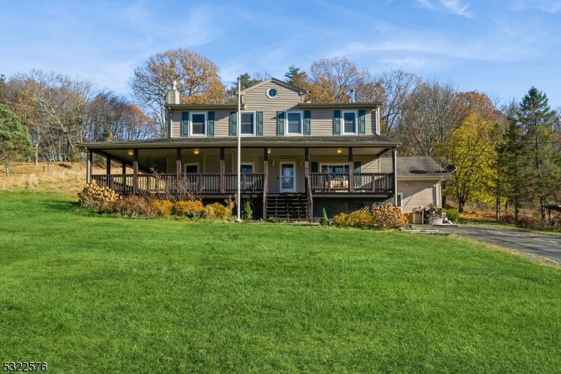 a view of a big house with a big yard and large trees