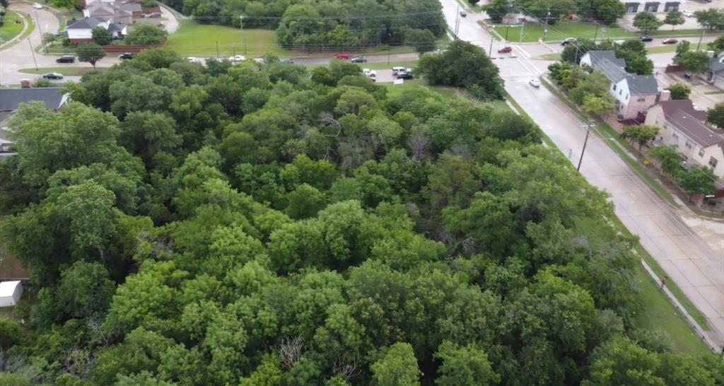 an aerial view of residential houses with outdoor space and trees all around