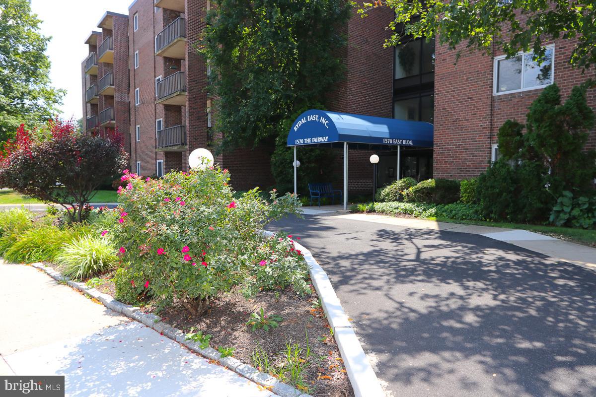 a front view of a house with a yard and potted plants