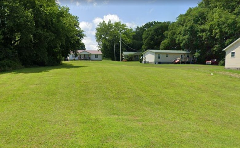 a front view of a house with a yard and trees