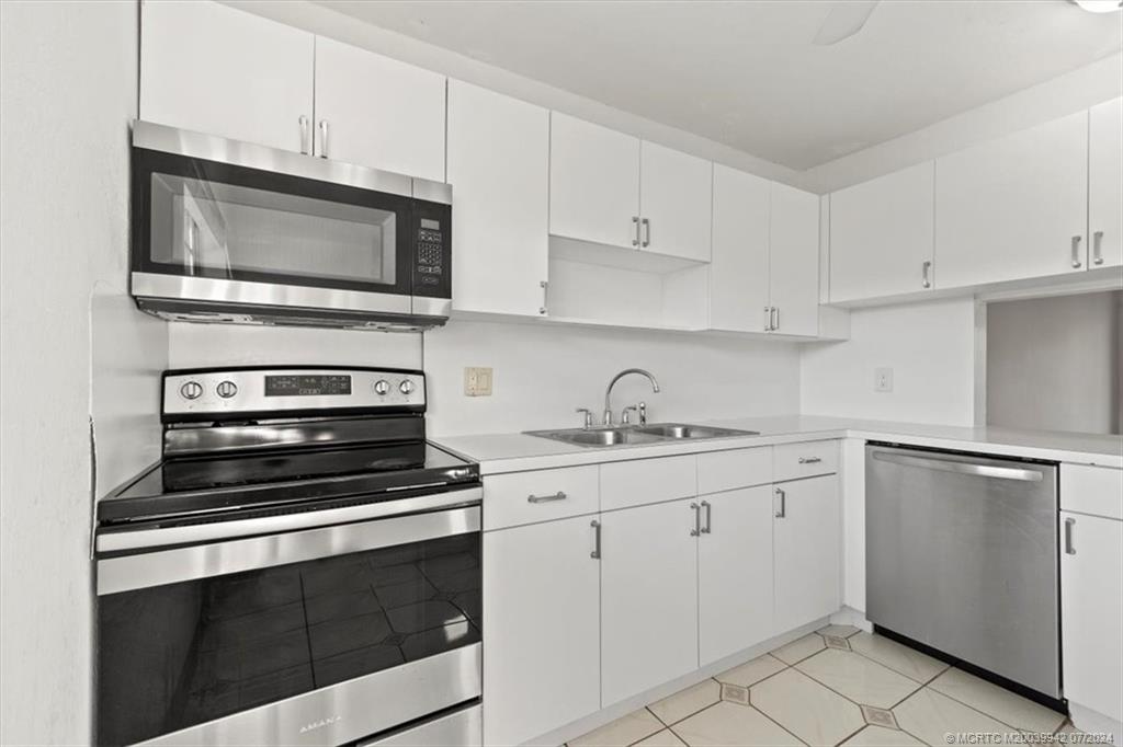 a kitchen with white cabinets stainless steel appliances and sink