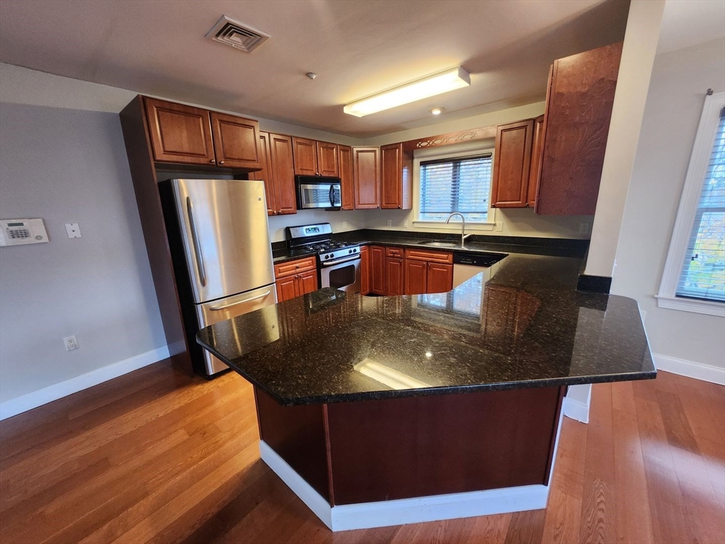 a room with table chairs and refrigerator