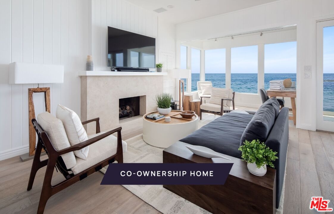 a living room with furniture a flat screen tv and a fireplace