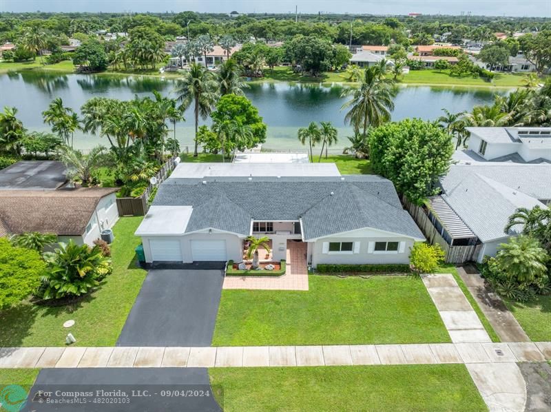 an aerial view of a house with garden space and a lake view