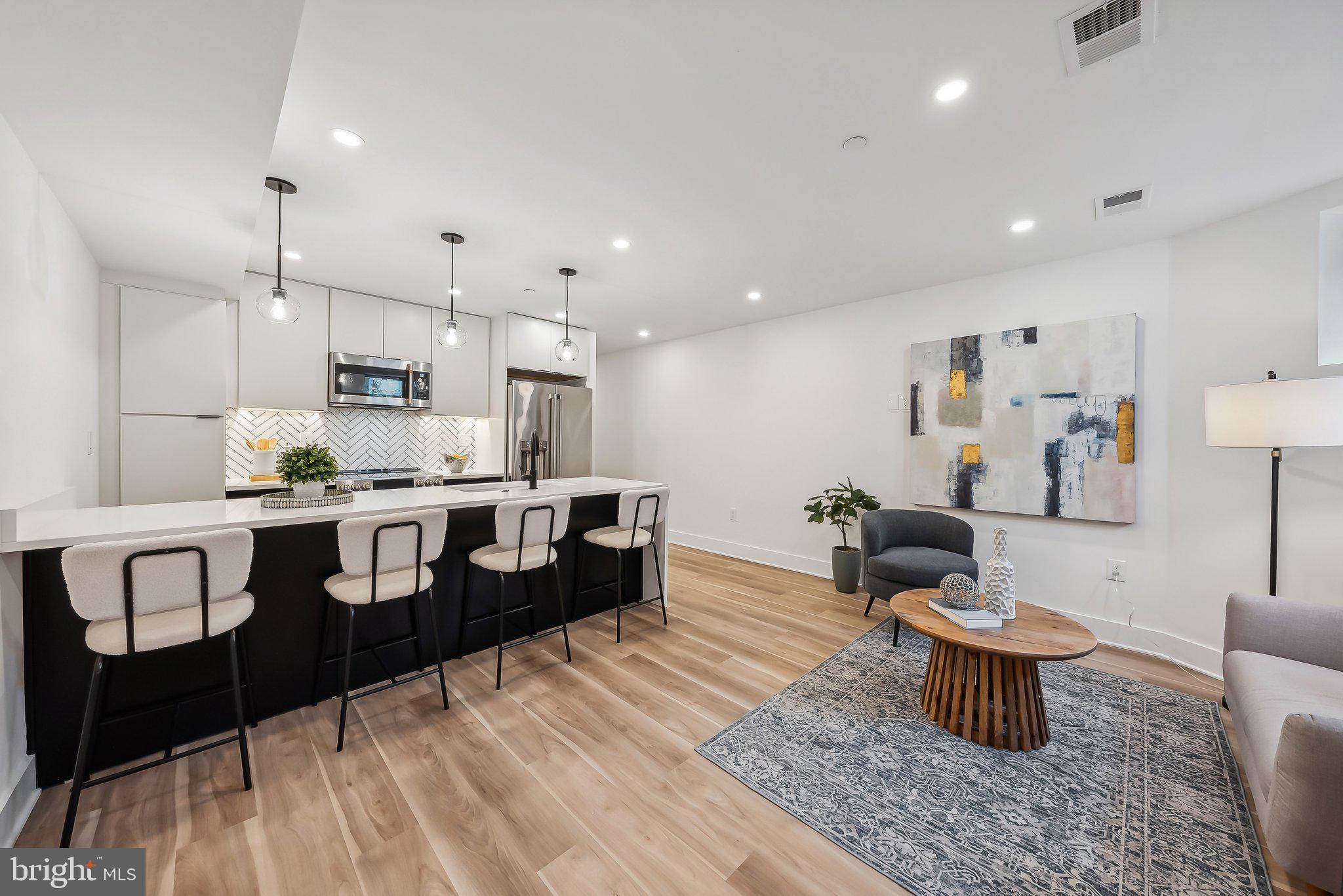 a large kitchen with stainless steel appliances kitchen island granite countertop a sink and a refrigerator