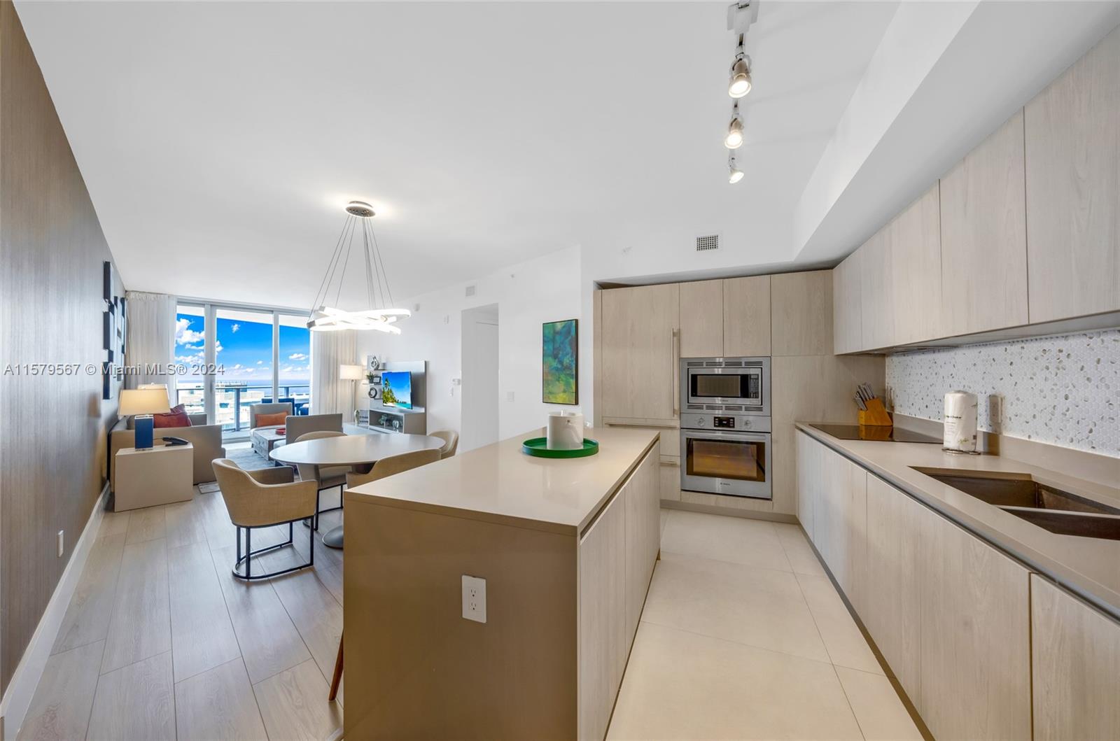 a kitchen with a sink a counter top space and stainless steel appliances