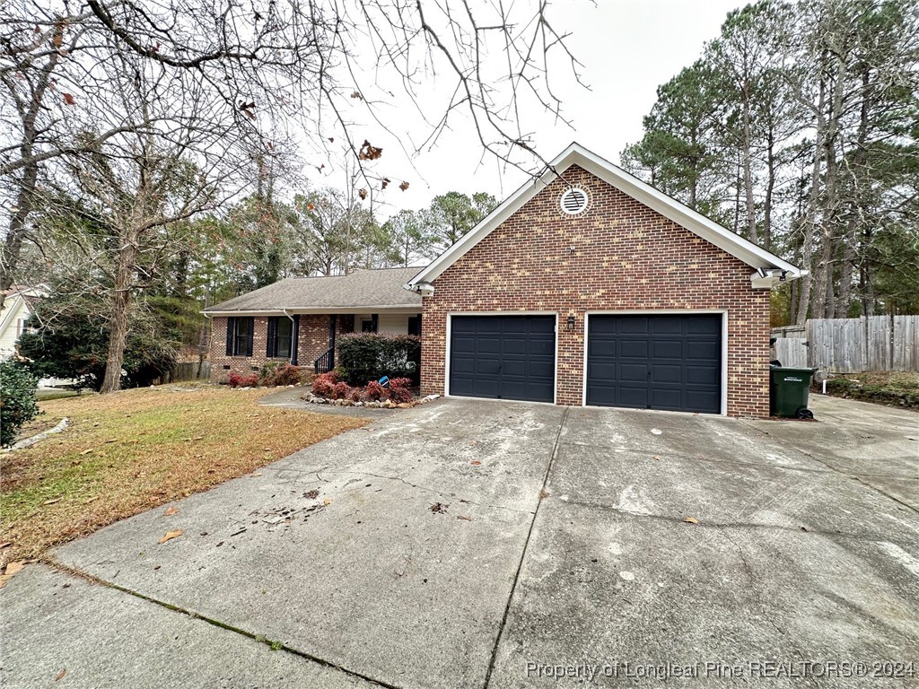 a front view of house with yard and trees around