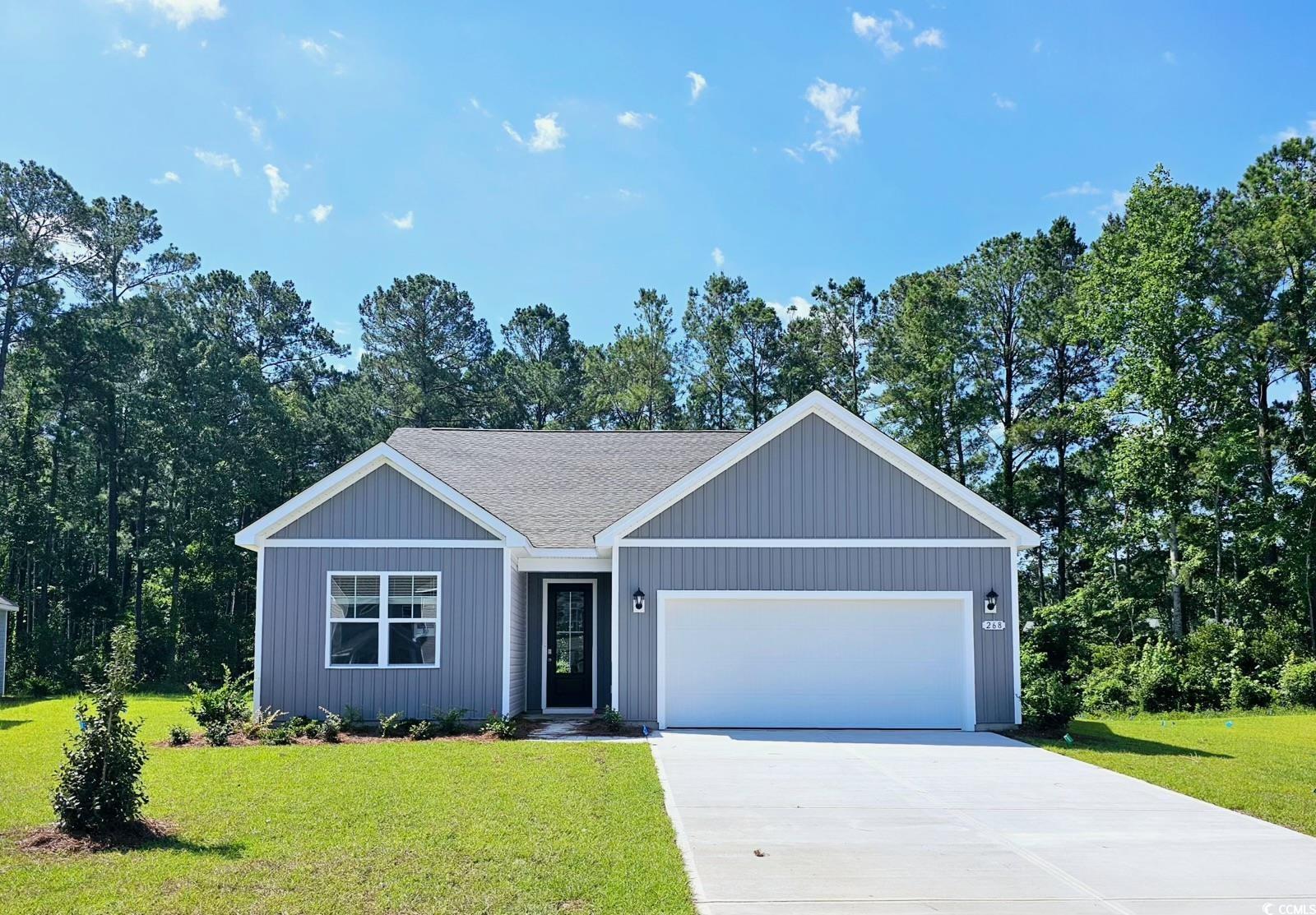 Ranch-style house featuring a front lawn and a gar