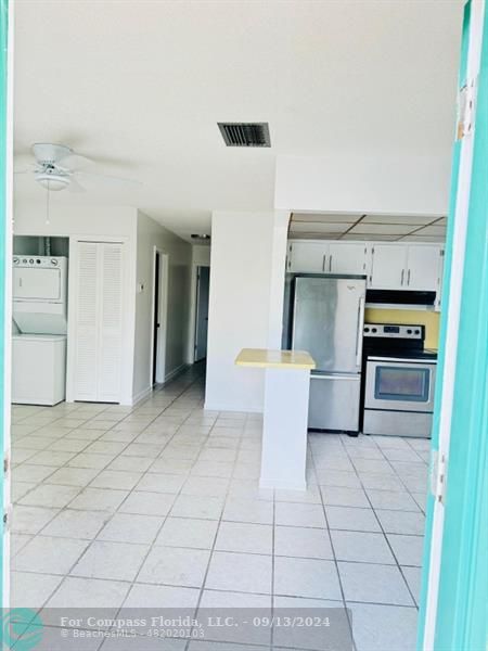 a kitchen with stainless steel appliances cabinets and front door