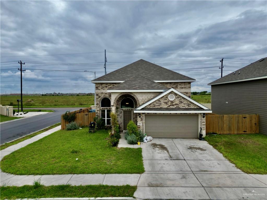 View of front of house with a garage and a front lawn