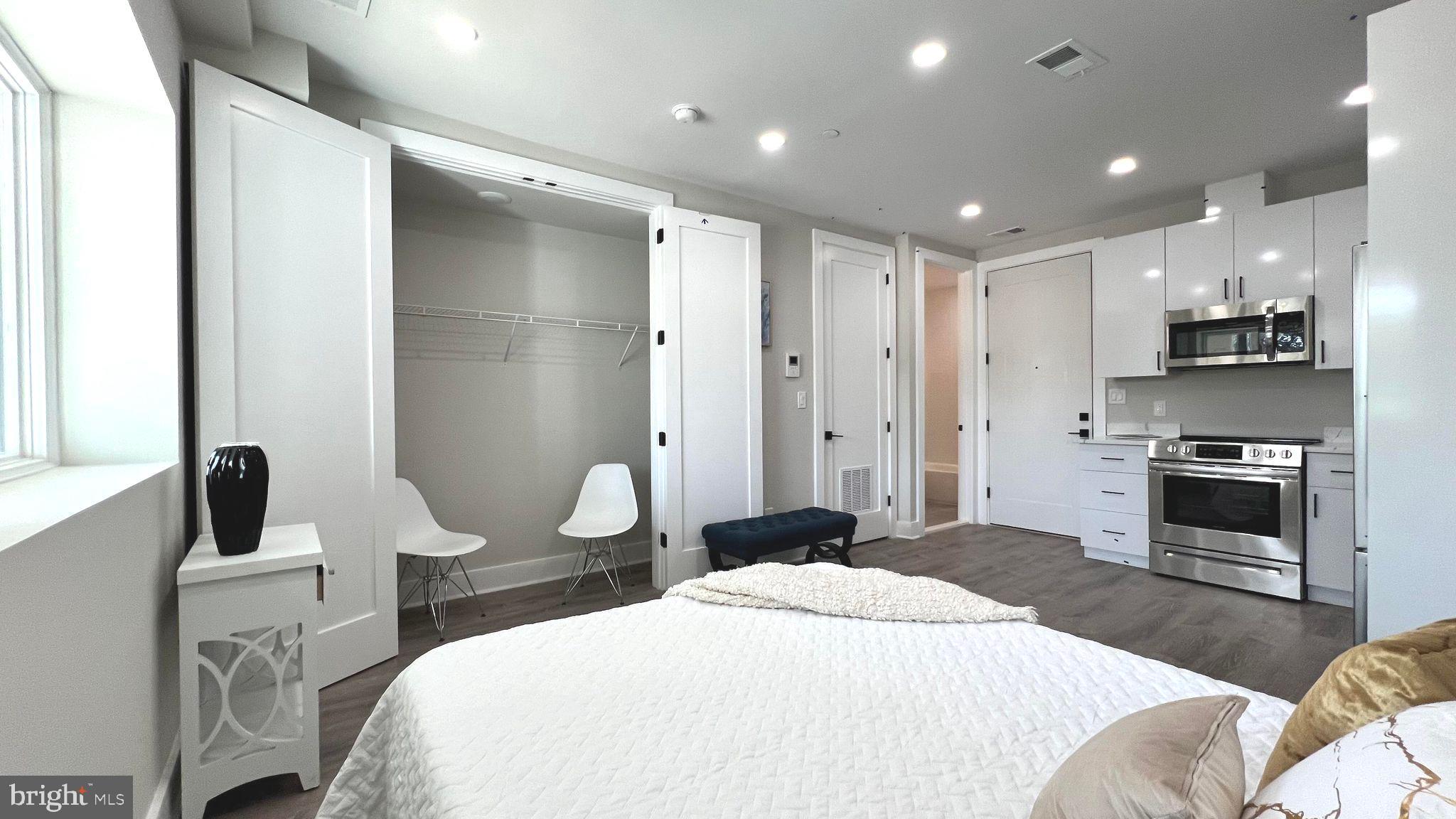 a bedroom with a bed and a view of kitchen