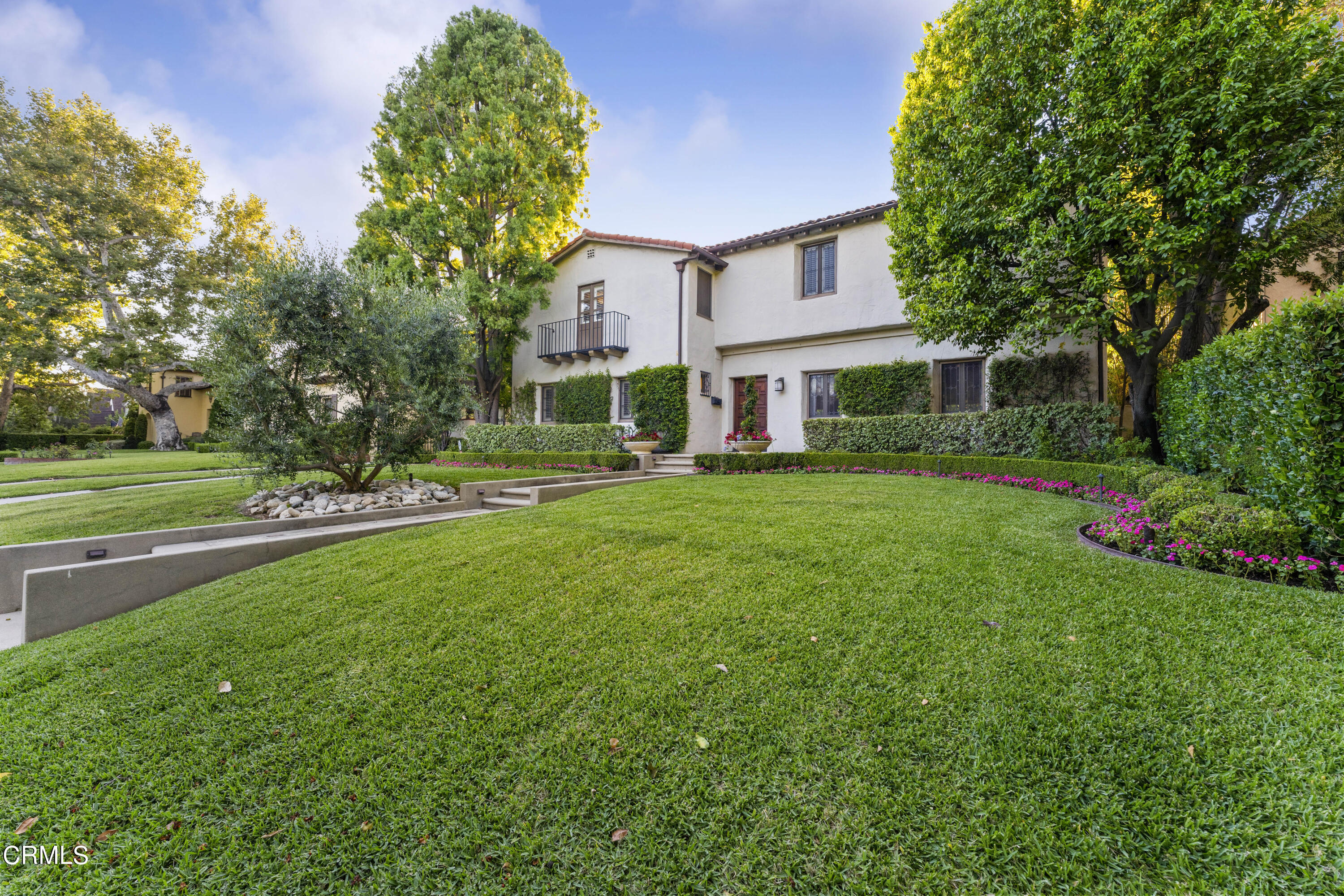 a view of a house with a big yard and large trees