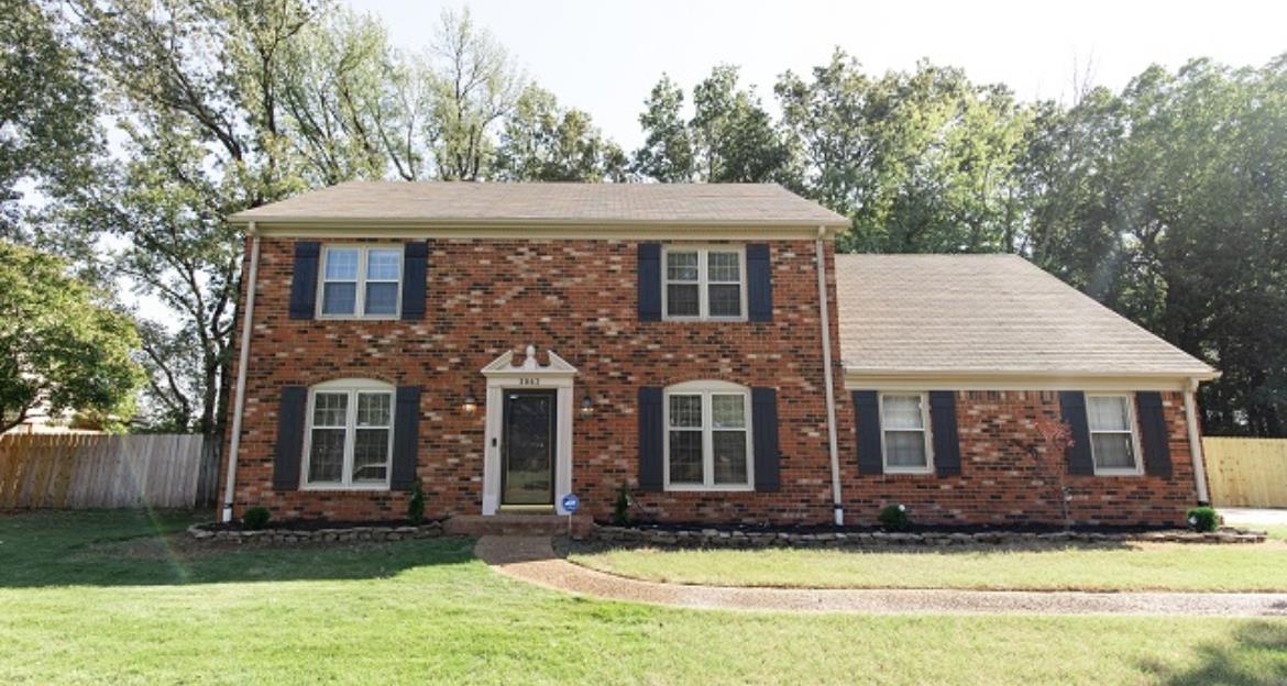 Colonial home featuring a front lawn