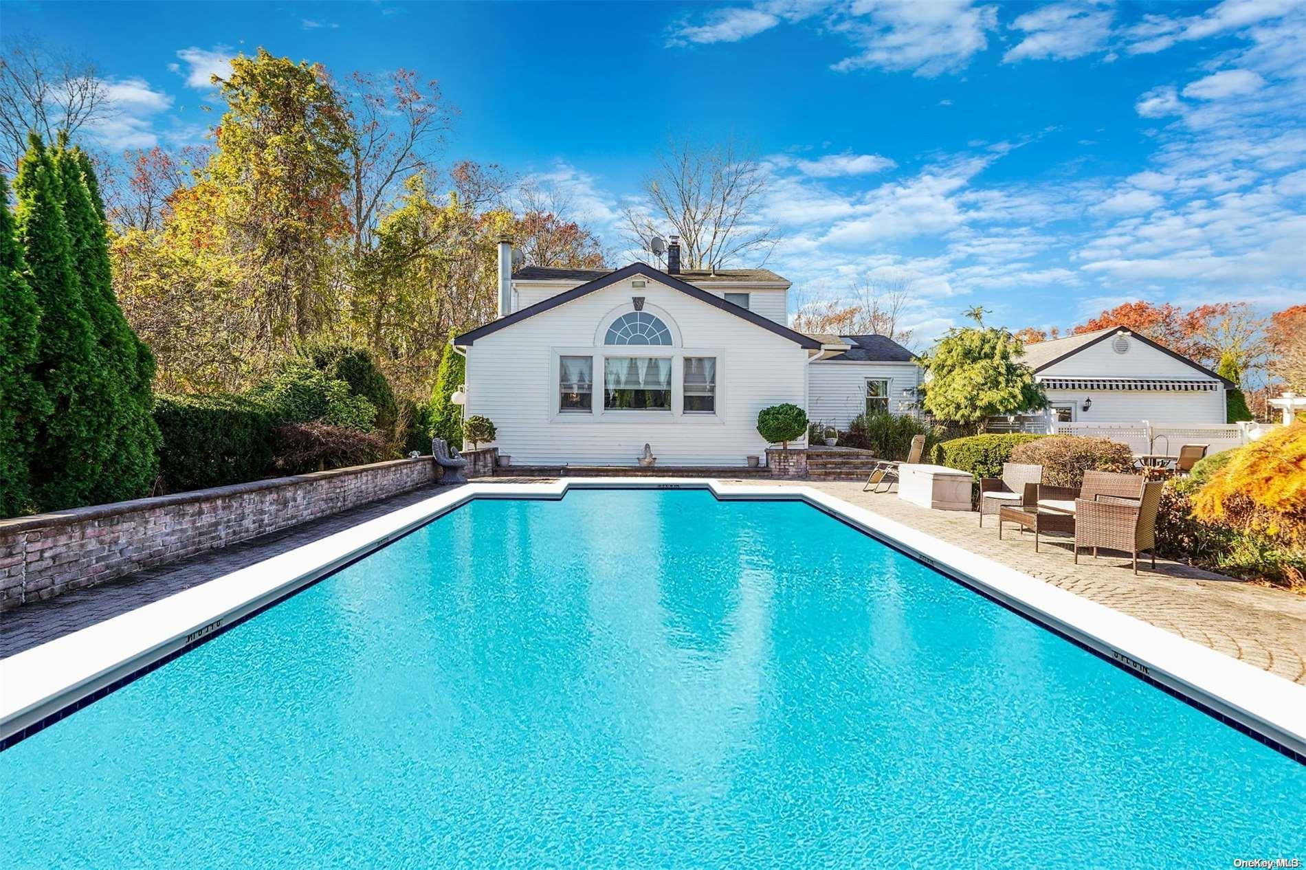 a view of a house with pool and sitting area