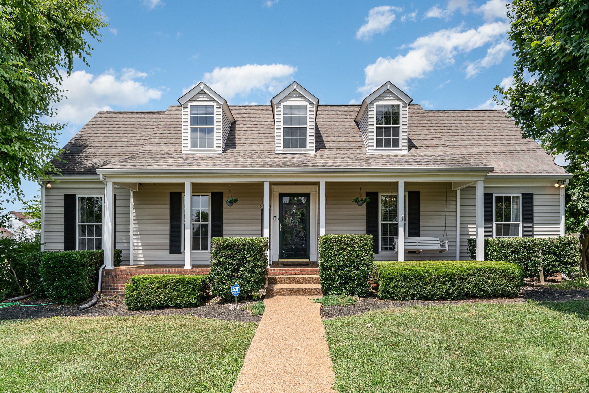 a front view of a house with garden and porch