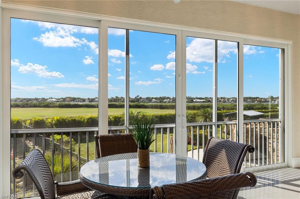 a view of a living room with furniture and floor to ceiling windows