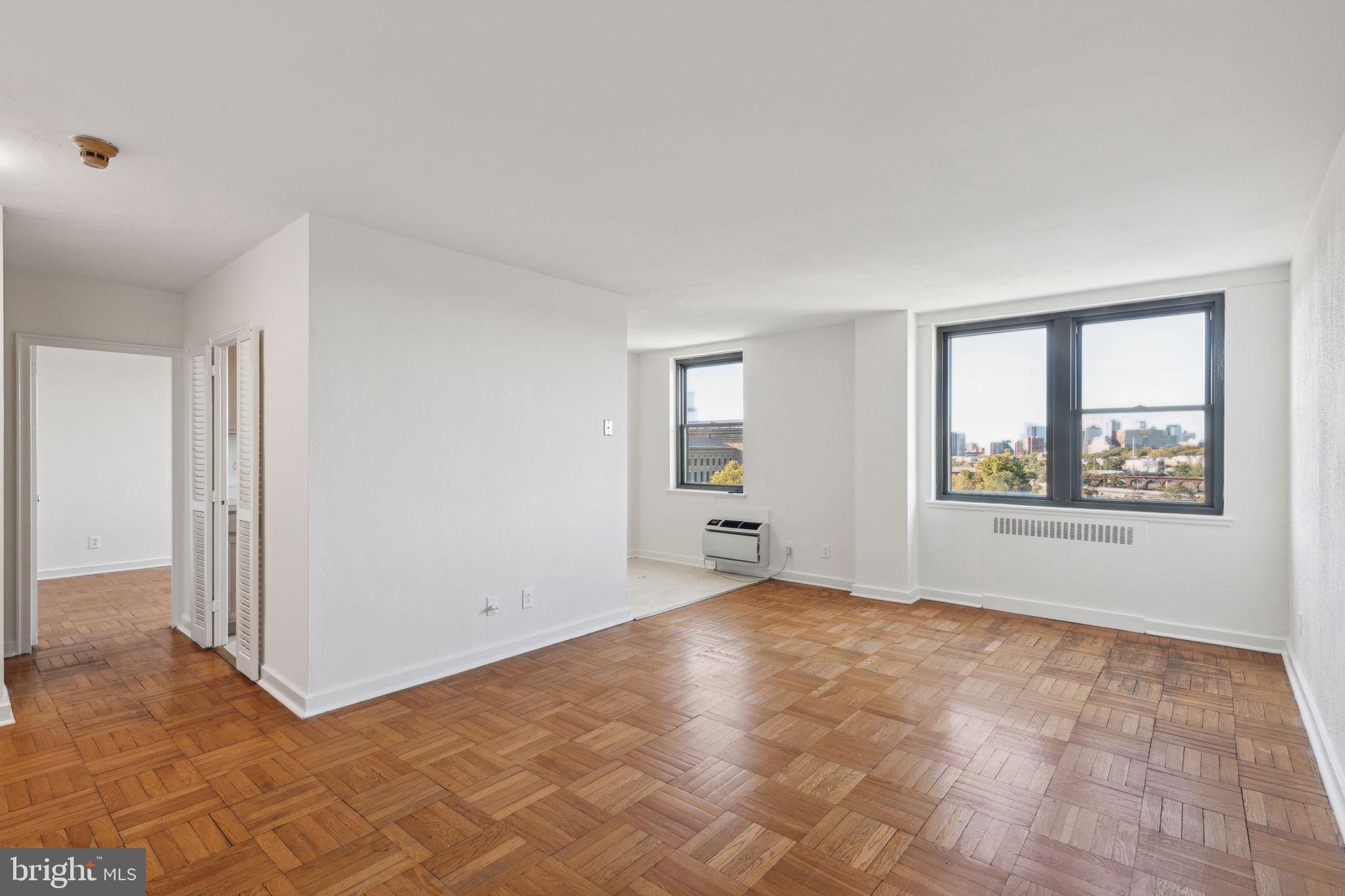 a view of an empty room with window and closet area