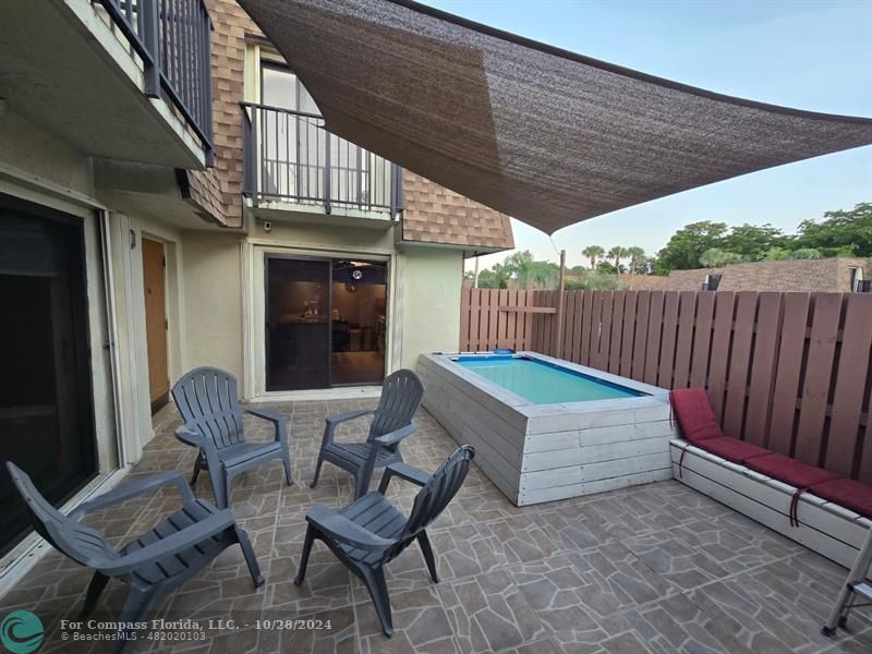 a roof deck with table and chairs and potted plants