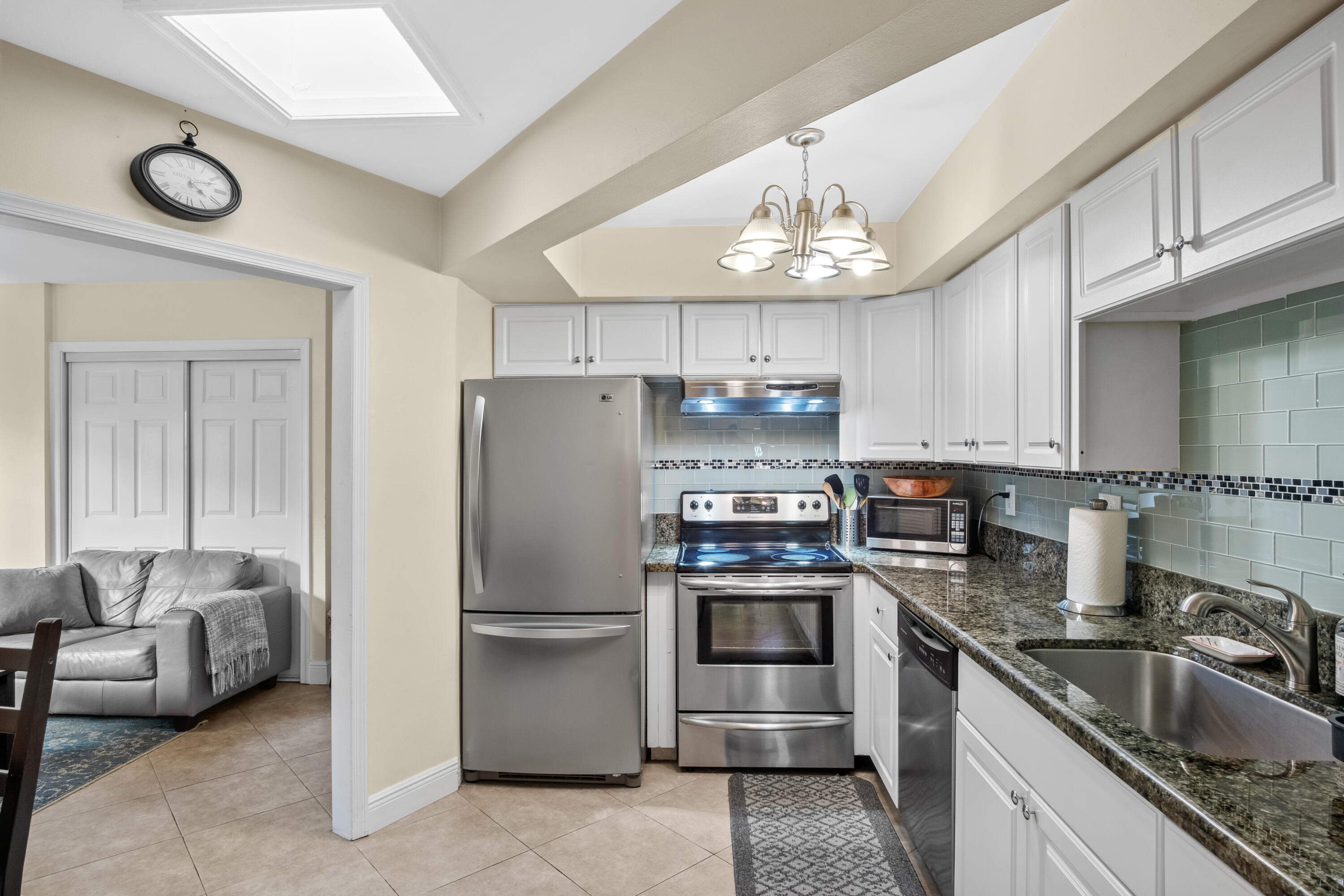 a kitchen with granite countertop a refrigerator stove and sink