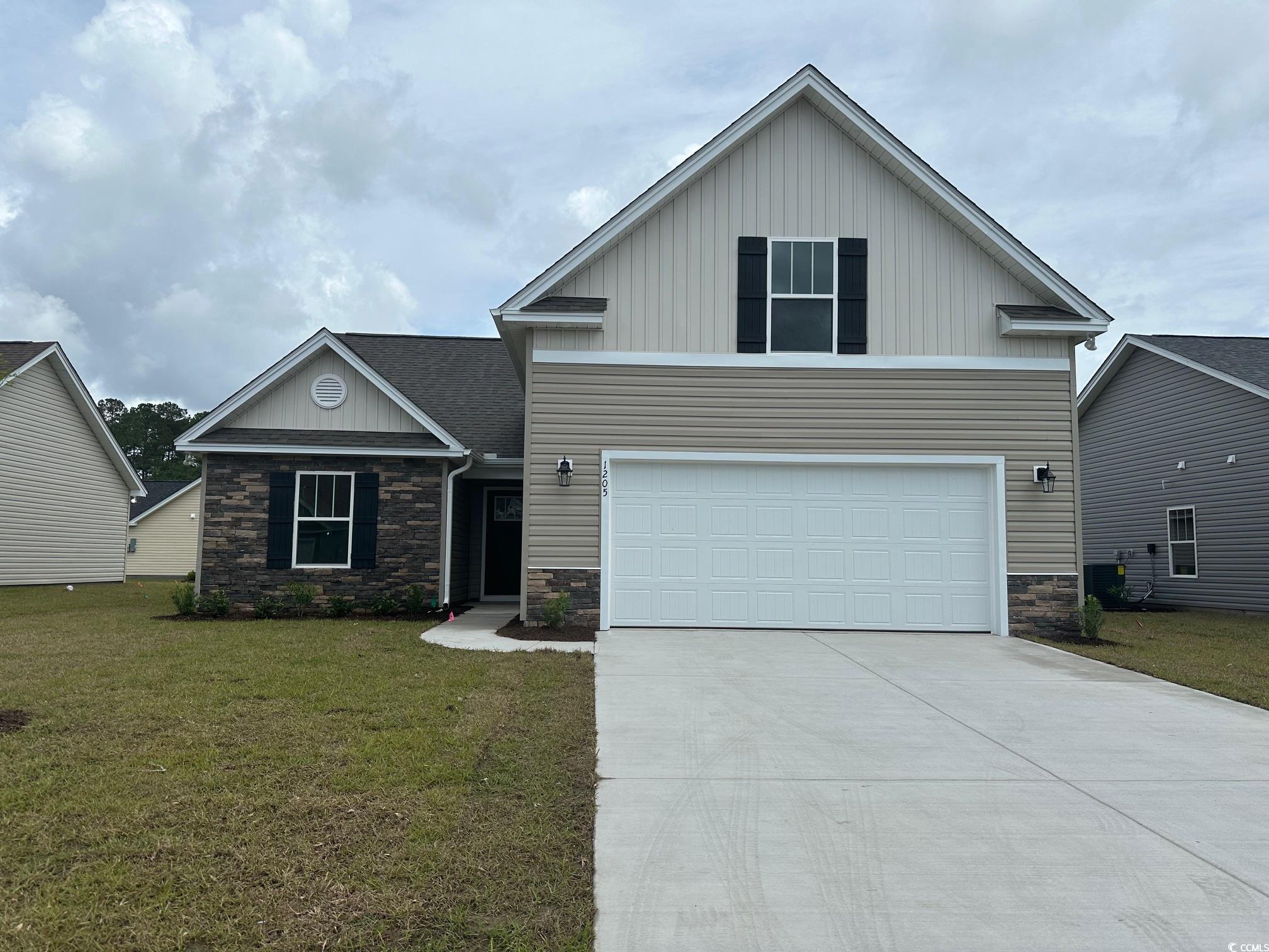 View of property with a garage and a front lawn