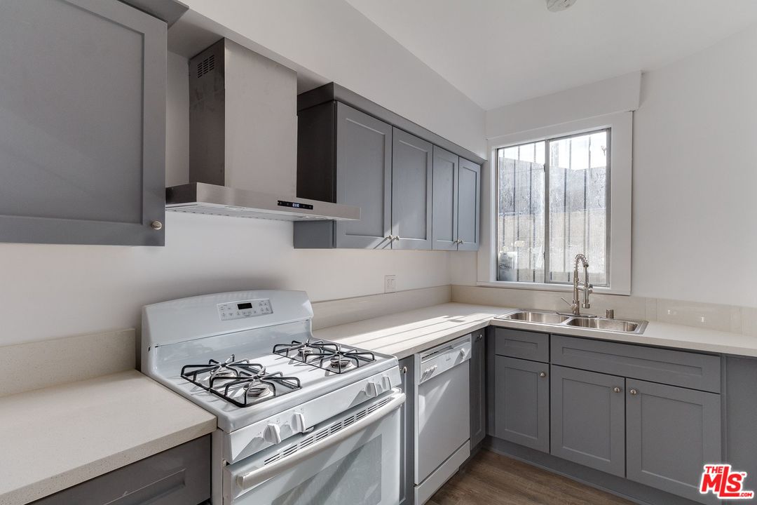 a kitchen with stainless steel appliances a sink a stove and cabinets