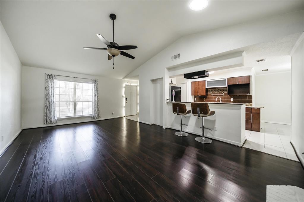 a view of a kitchen with a sink an oven wooden floor and a window