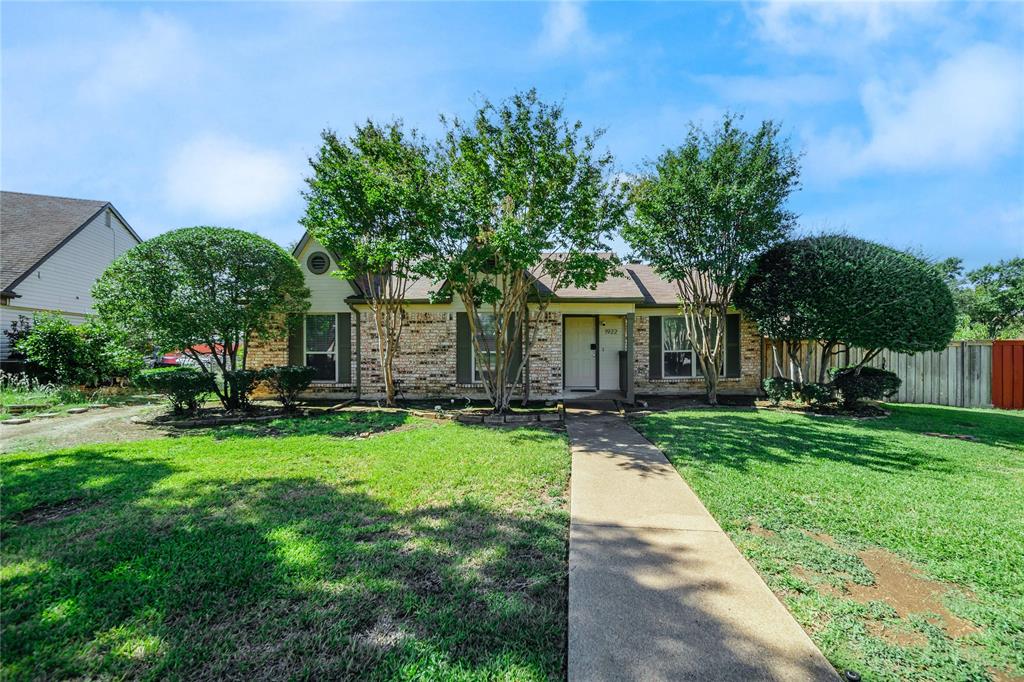 a view of a house with backyard and a tree