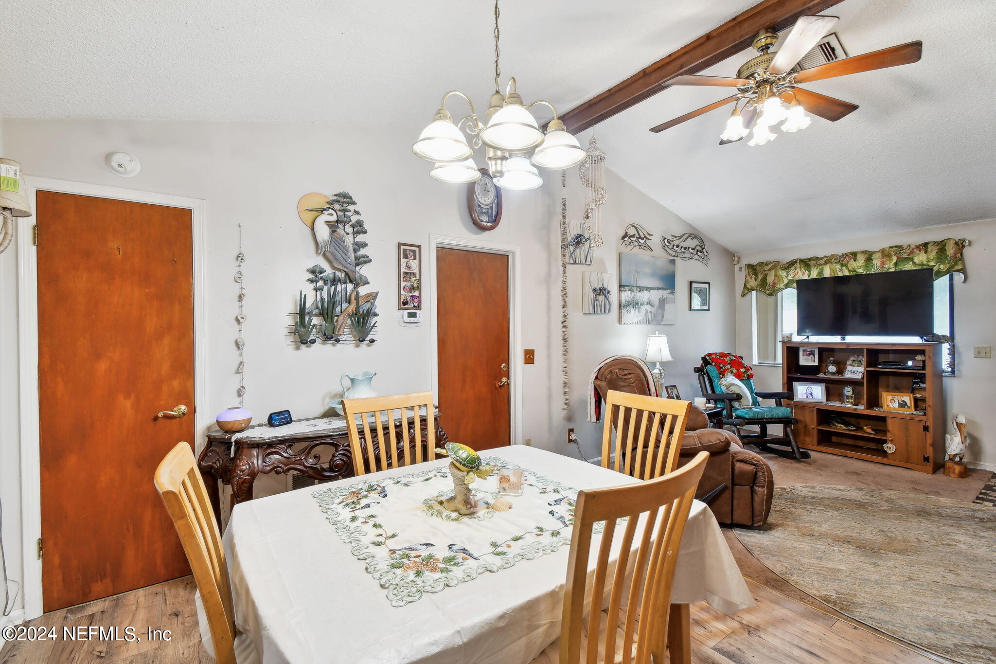 a dining room with wooden floor a chandelier a wooden table and chairs