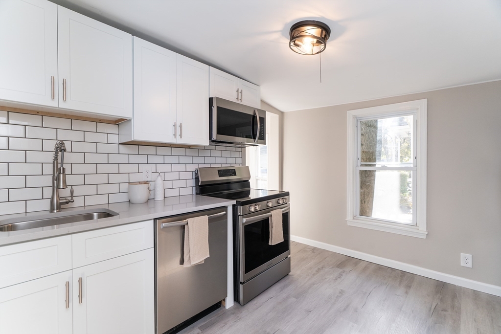 a kitchen with cabinets stainless steel appliances a sink and a window