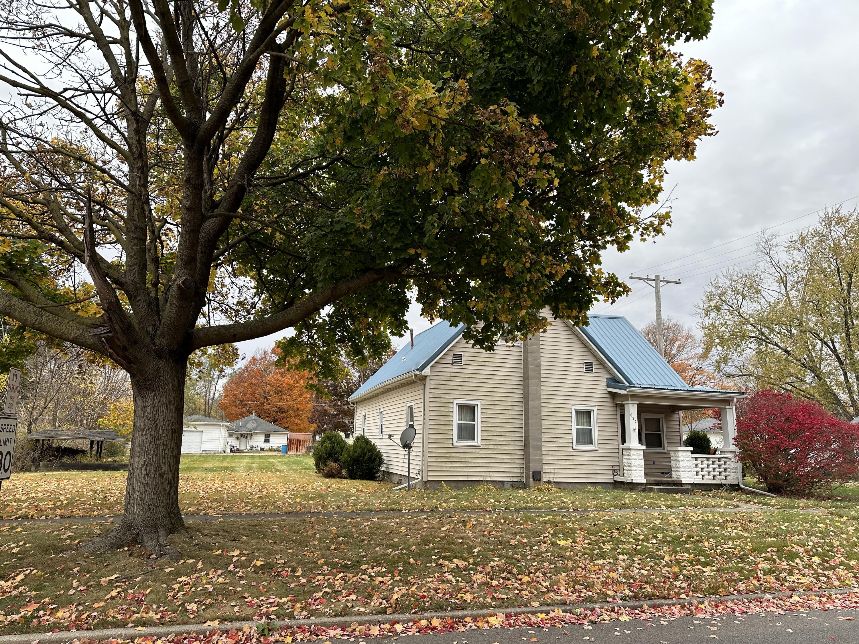 a white house that has a tree in front of it