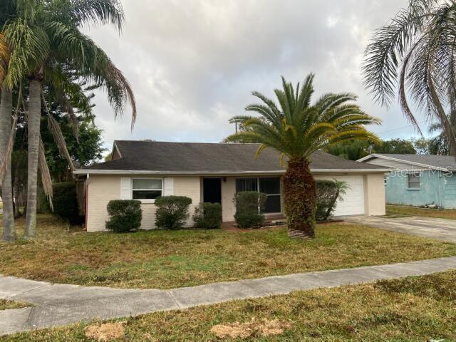 a front view of house with yard and trees around