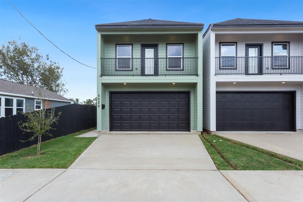 a front view of a house with yard and parking