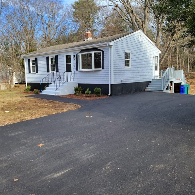 a view of a house with a yard and large tree