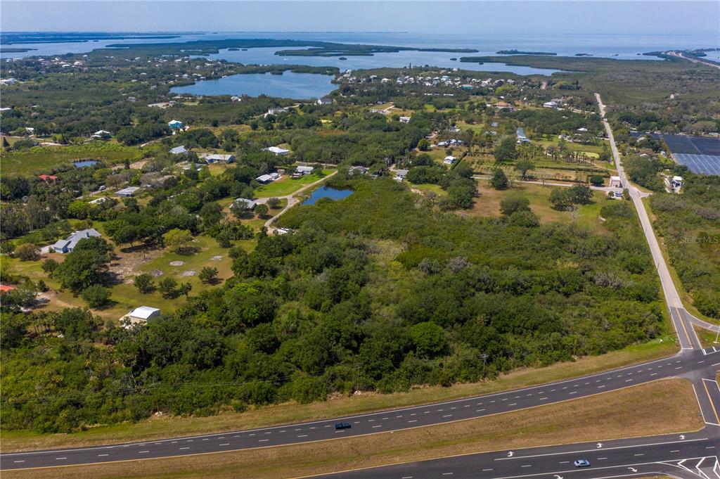 an aerial view of residential houses with outdoor space and trees