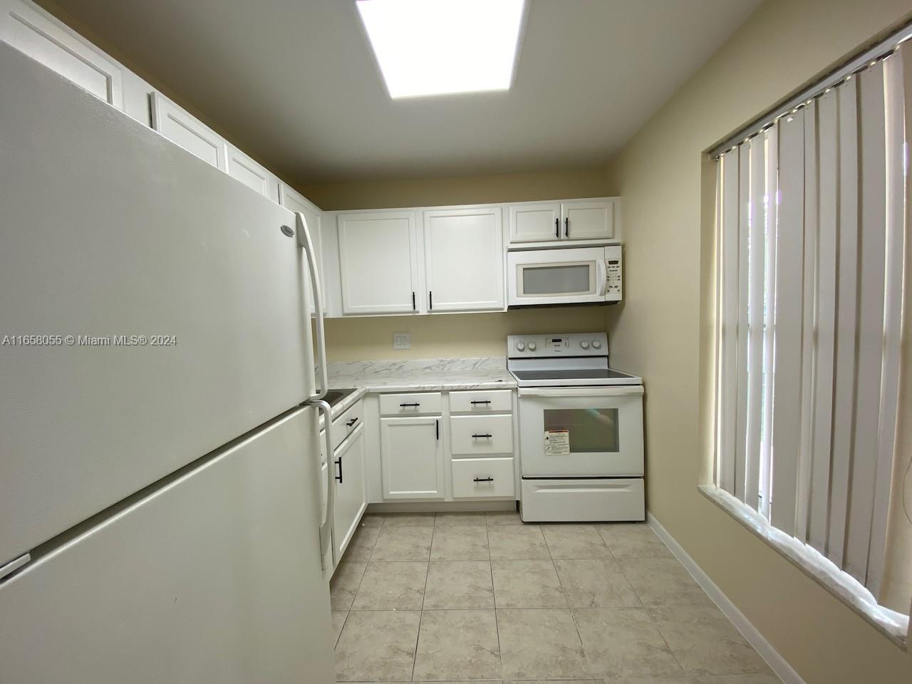 a kitchen with granite countertop white cabinets and stainless steel appliances