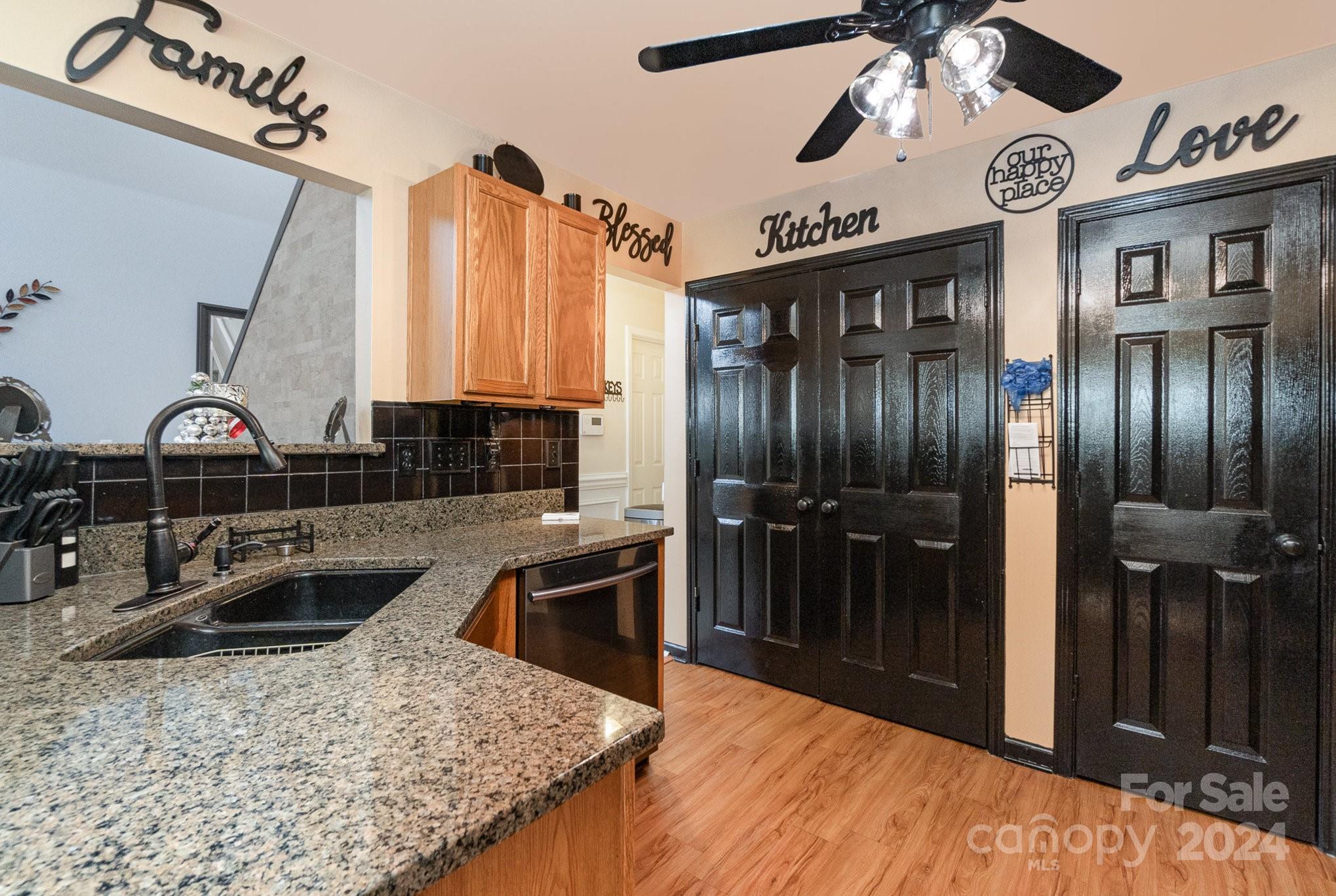 a kitchen with stainless steel appliances granite countertop a sink and a refrigerator