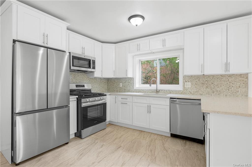 a kitchen with stainless steel appliances a refrigerator sink and microwave