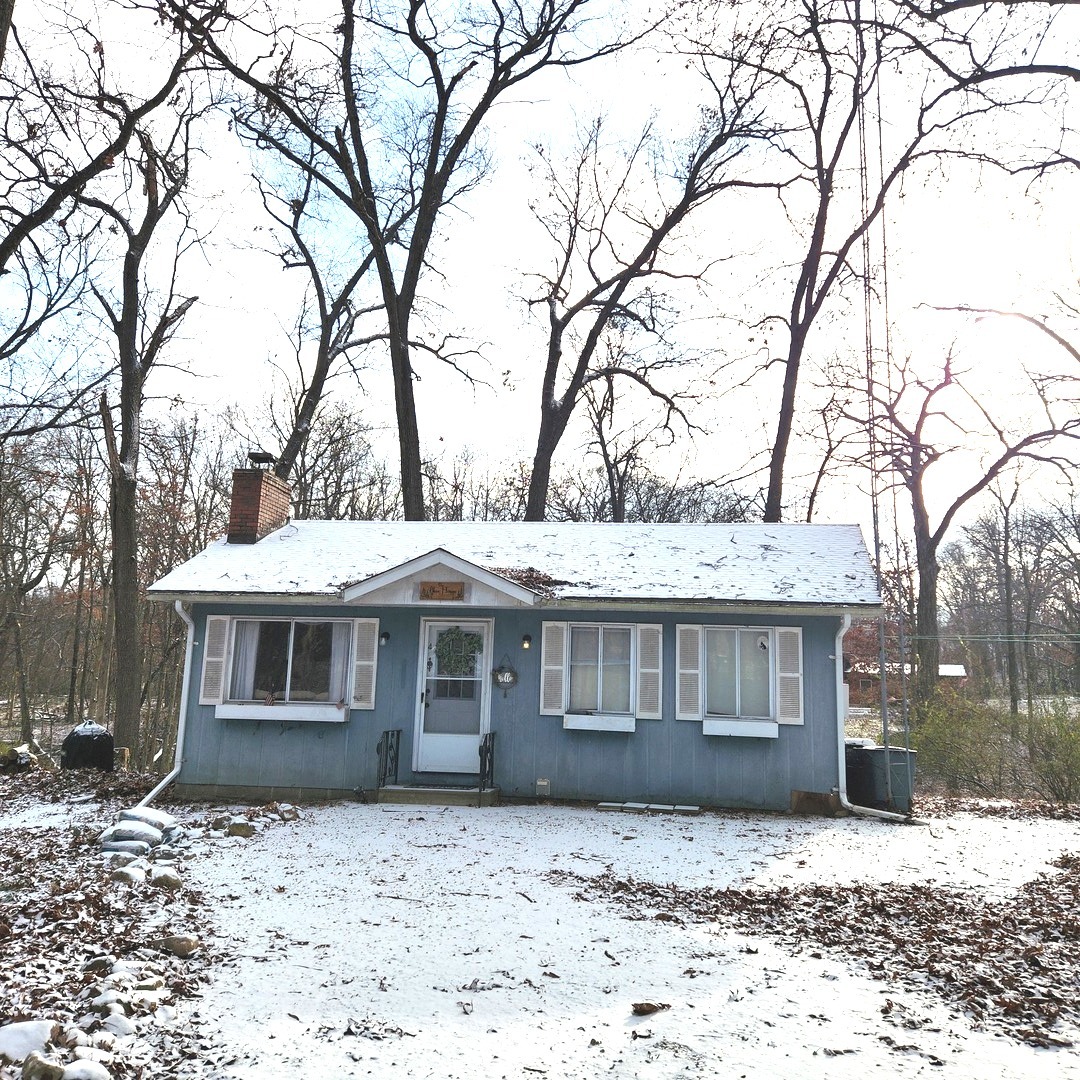 a front view of a house with a yard covered with snow