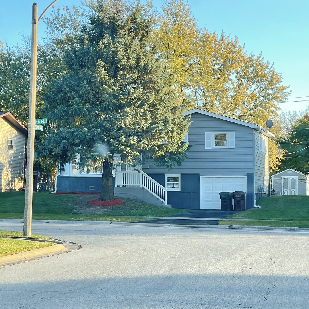 a view of a house with a yard and tree s