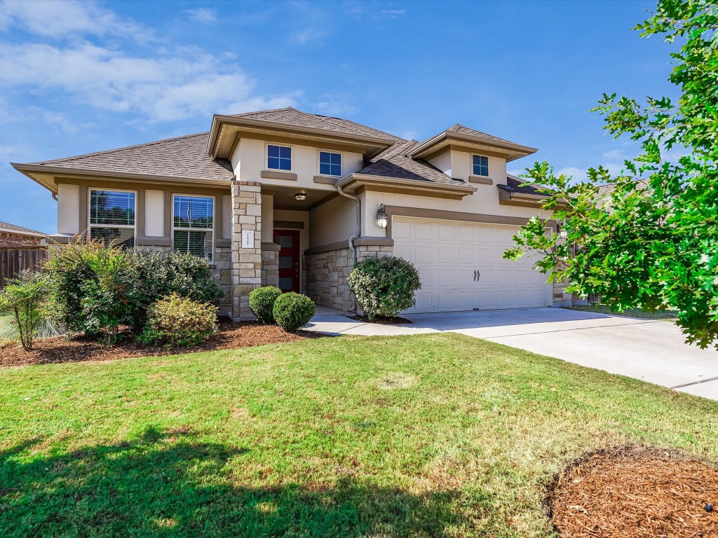 a front view of a house with a yard and garage