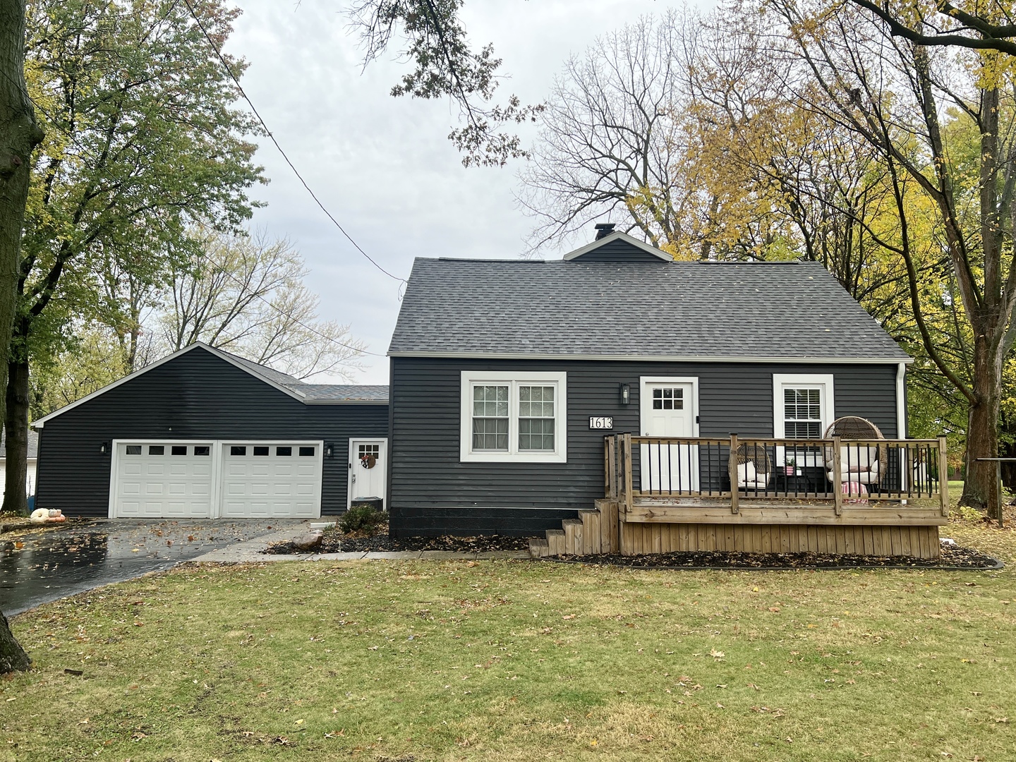 a front view of a house with a yard tree and outdoor seating