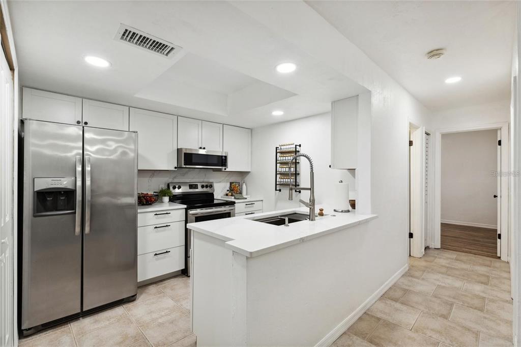 a kitchen that has a refrigerator a sink and cabinets